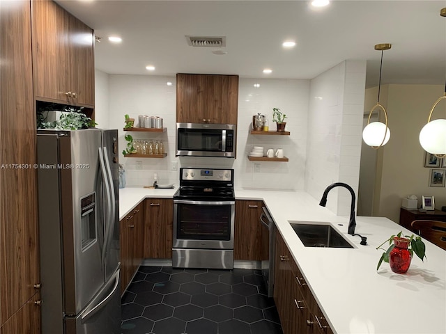 kitchen featuring open shelves, light countertops, visible vents, appliances with stainless steel finishes, and a sink