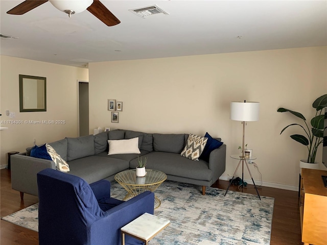 living area with visible vents, ceiling fan, baseboards, and wood finished floors