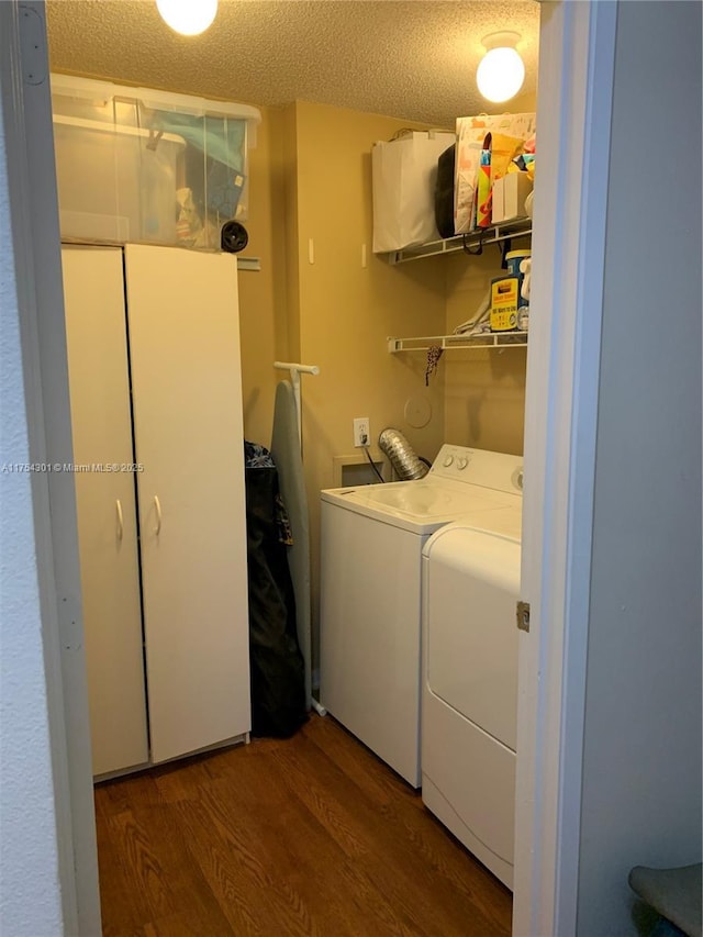 laundry room featuring laundry area, a textured ceiling, separate washer and dryer, and wood finished floors