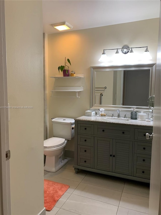 bathroom with vanity, tile patterned flooring, and toilet