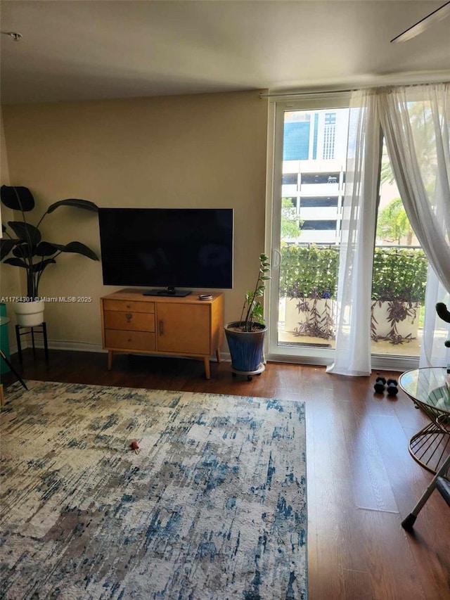 living area featuring baseboards and wood finished floors