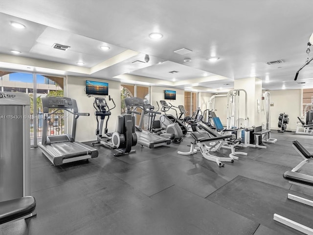 exercise room featuring a raised ceiling and visible vents