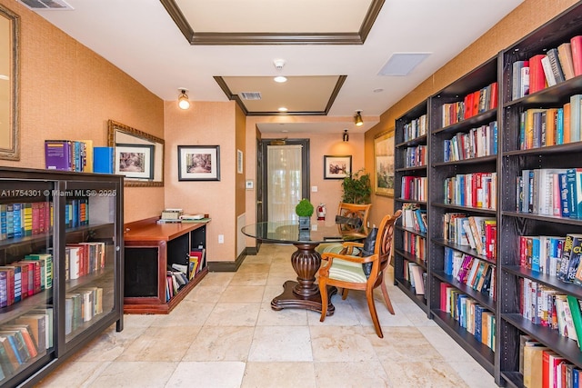 office space featuring wall of books, visible vents, and baseboards