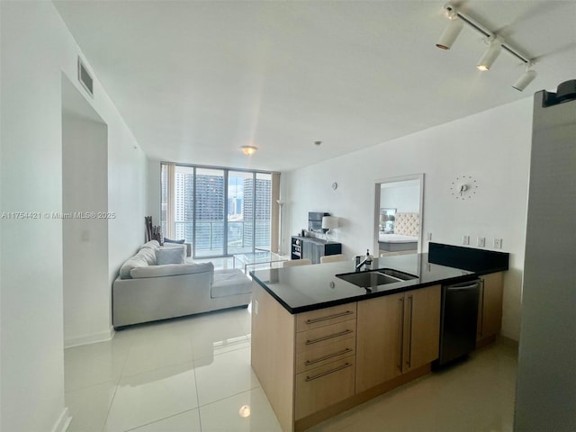 kitchen featuring dark countertops, visible vents, rail lighting, a sink, and a peninsula