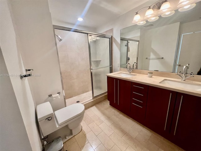 full bathroom featuring toilet, a stall shower, double vanity, and a sink