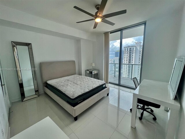 bedroom featuring a city view, access to outside, floor to ceiling windows, and light tile patterned floors