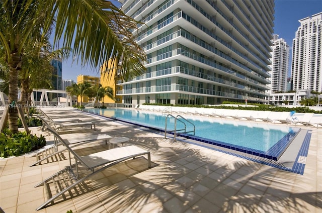 community pool with a city view and a patio area