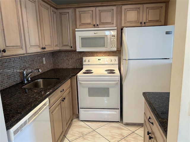 kitchen with white appliances, dark stone counters, decorative backsplash, and a sink