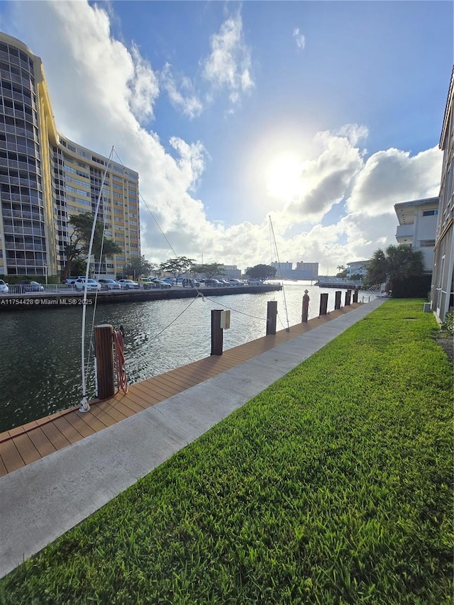 dock area with a water view and a yard