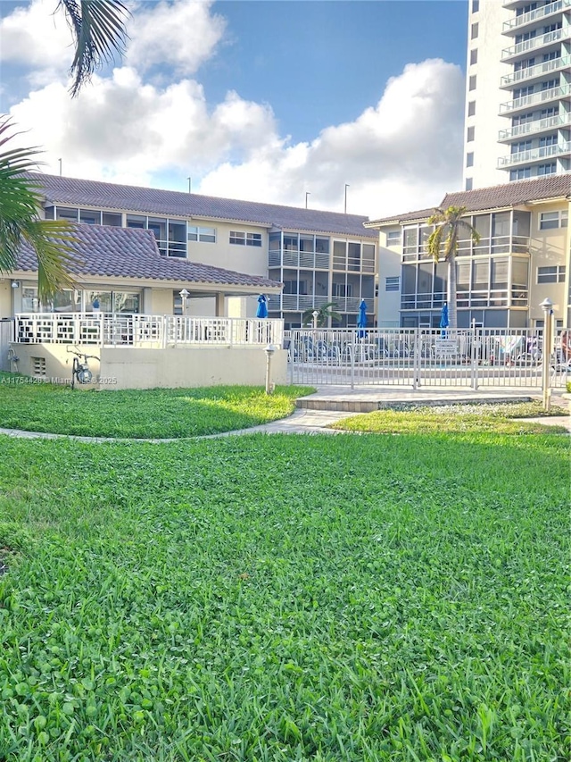 view of home's community featuring a lawn and fence