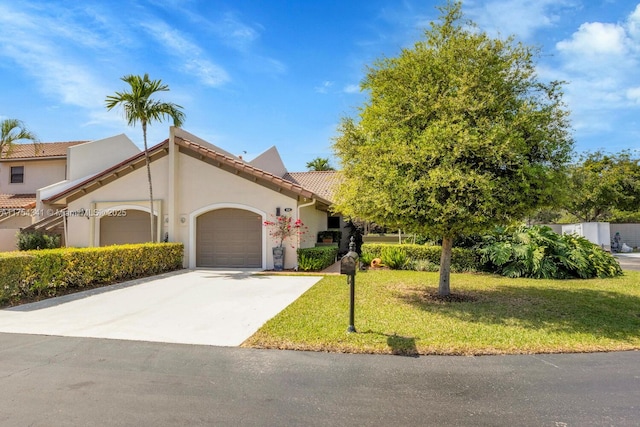 view of front of home with stucco siding, concrete driveway, a front yard, a garage, and a tiled roof