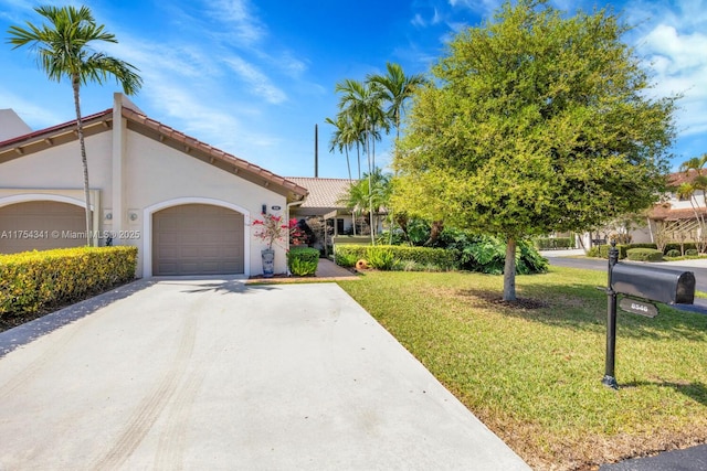 view of front of property with stucco siding, concrete driveway, an attached garage, a tiled roof, and a front lawn