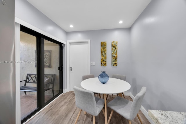 dining room with recessed lighting, baseboards, and light wood finished floors