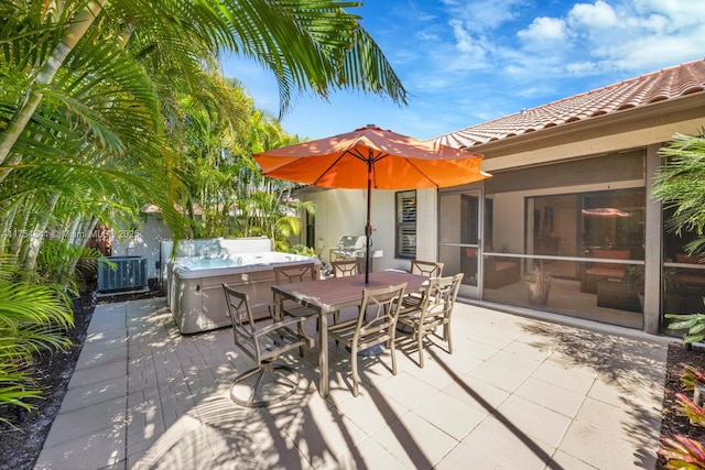 view of patio with a sunroom, a hot tub, outdoor dining area, and central AC