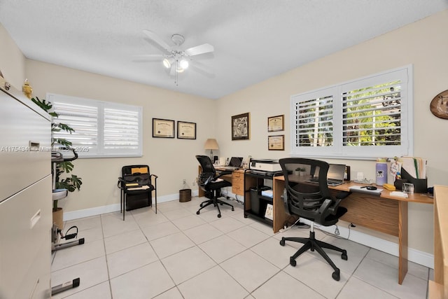 office featuring light tile patterned floors, a textured ceiling, a ceiling fan, and baseboards