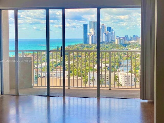 empty room with a water view, a view of city, and floor to ceiling windows