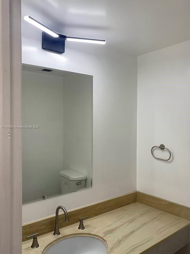 bathroom featuring visible vents, vanity, and toilet