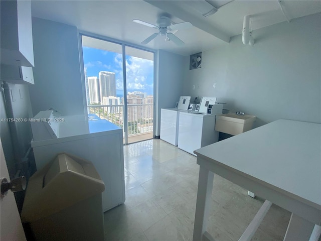 community laundry room with washing machine and dryer, a view of city, ceiling fan, and a sink