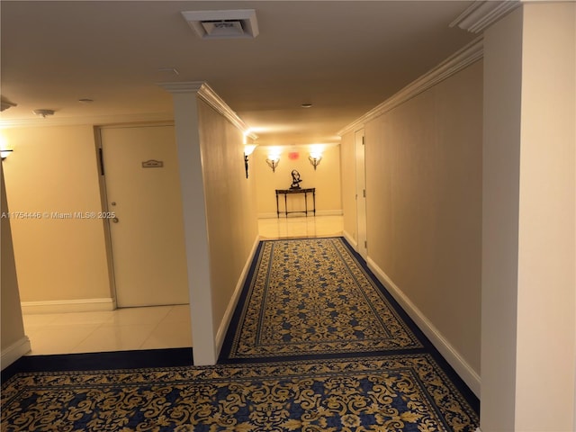 hallway with baseboards, ornamental molding, visible vents, and tile patterned floors