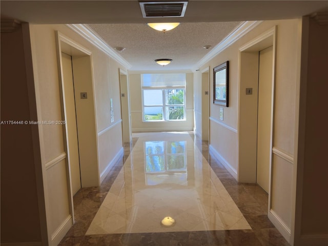 hallway featuring marble finish floor, visible vents, ornamental molding, elevator, and a textured ceiling