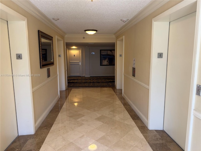 hall with a textured ceiling, baseboards, marble finish floor, ornamental molding, and elevator