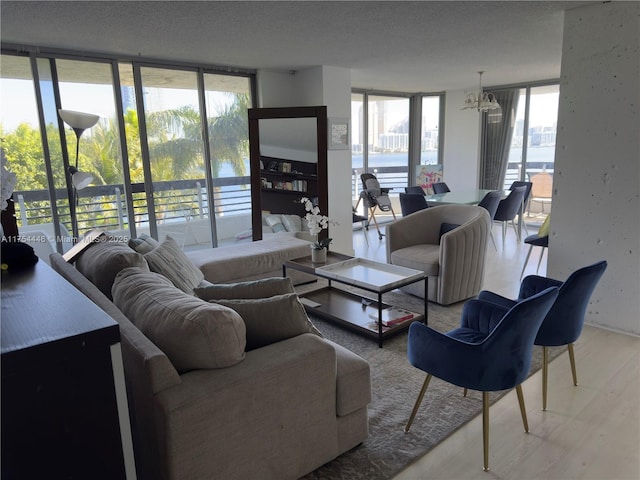 living area featuring floor to ceiling windows, light wood-style flooring, and an inviting chandelier