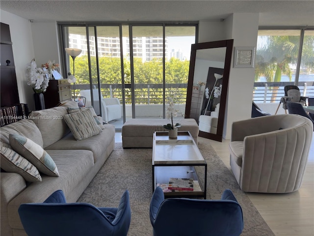 living room featuring a textured ceiling, wood finished floors, and floor to ceiling windows