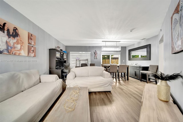 living area with visible vents and wood finished floors