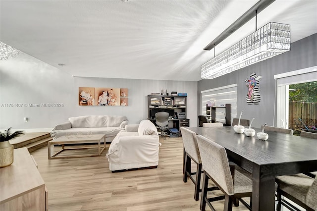 dining space featuring light wood-type flooring and lofted ceiling