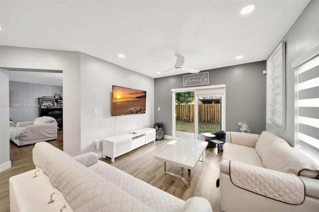 living room featuring baseboards, wood finished floors, and recessed lighting