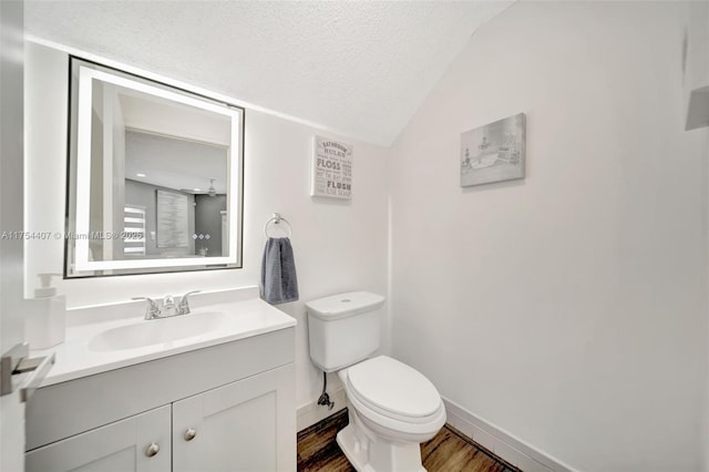 bathroom featuring a textured ceiling, toilet, wood finished floors, vanity, and vaulted ceiling