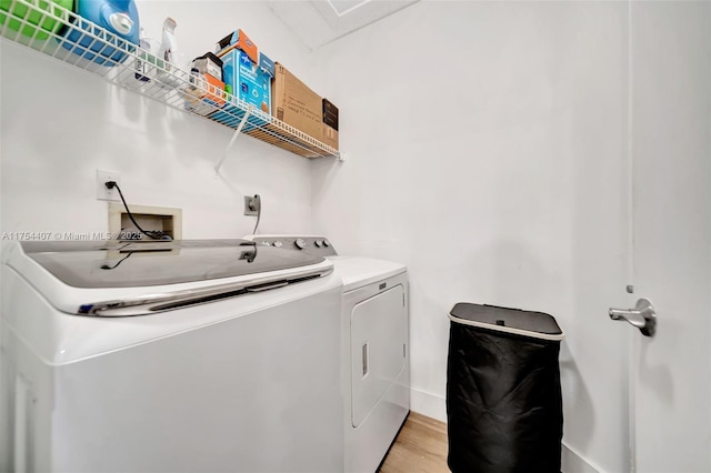 washroom featuring light wood-style floors, laundry area, and independent washer and dryer