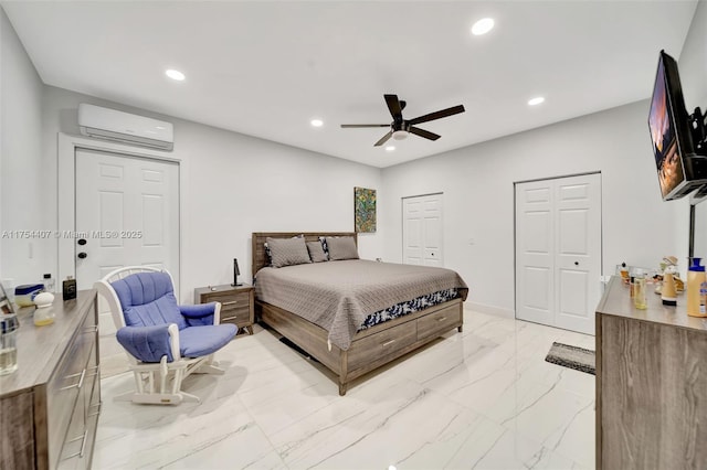 bedroom featuring multiple closets, recessed lighting, marble finish floor, and a wall unit AC