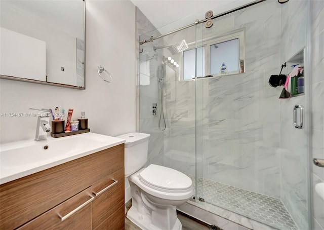 full bath with a stall shower, vanity, and toilet