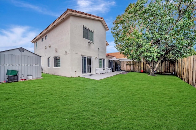 back of house featuring a patio, a fenced backyard, a tile roof, a yard, and stucco siding