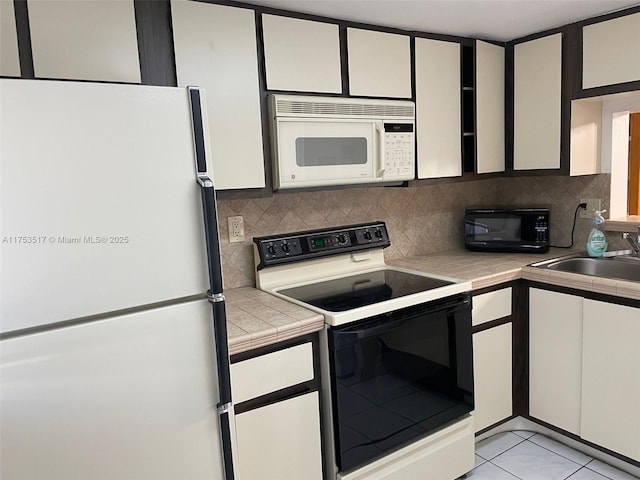 300 NW 107th Ave Unit 106, Miami, FL 33172 - kitchen featuring tile countertops, a sink, white appliances, decorative backsplash, and white cabinetry