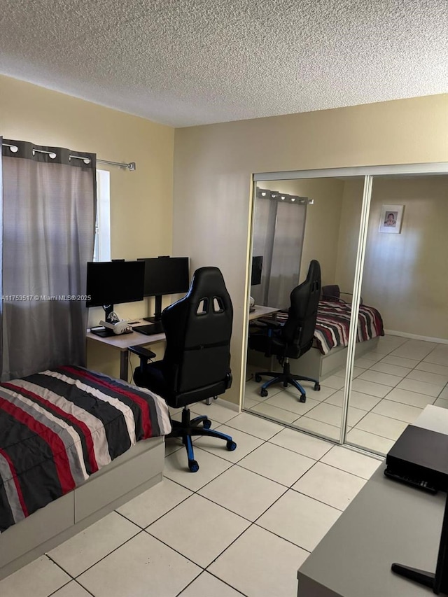 300 NW 107th Ave Unit 106, Miami, FL 33172 - bedroom with light tile patterned flooring, a textured ceiling, and baseboards