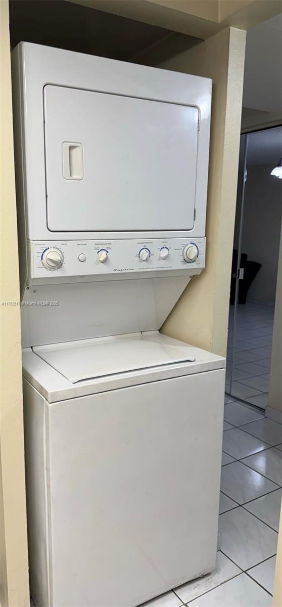 300 NW 107th Ave Unit 106, Miami, FL 33172 - clothes washing area featuring stacked washer / drying machine, laundry area, and light tile patterned floors