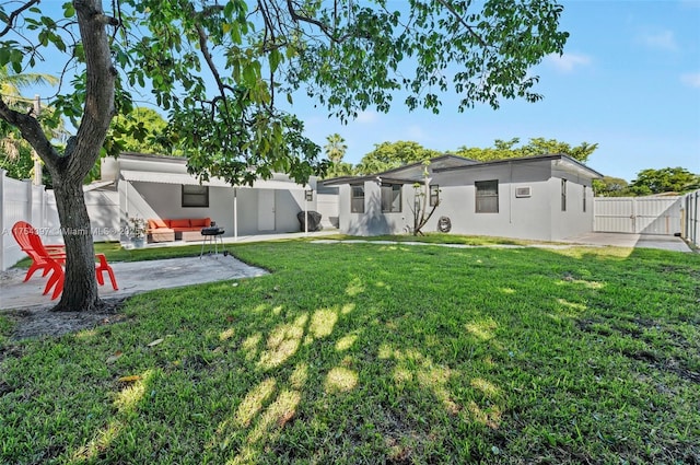 rear view of property featuring a yard, a fenced backyard, a patio, and stucco siding