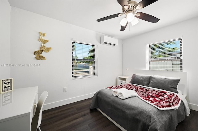 bedroom featuring a wall unit AC, a ceiling fan, baseboards, and wood finished floors