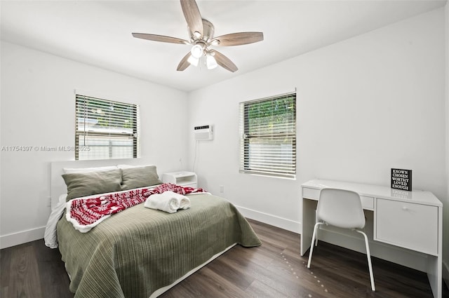 bedroom featuring a wall unit AC, wood finished floors, and baseboards