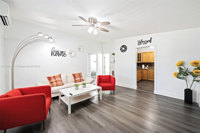 living area with ceiling fan, an AC wall unit, dark wood-style flooring, and baseboards