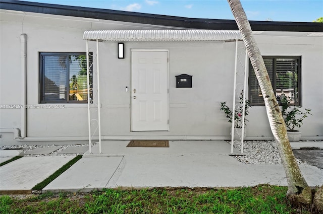 entrance to property featuring stucco siding