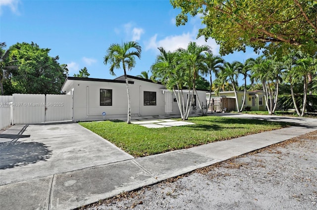 view of front of property with a front yard, fence, a gate, and stucco siding