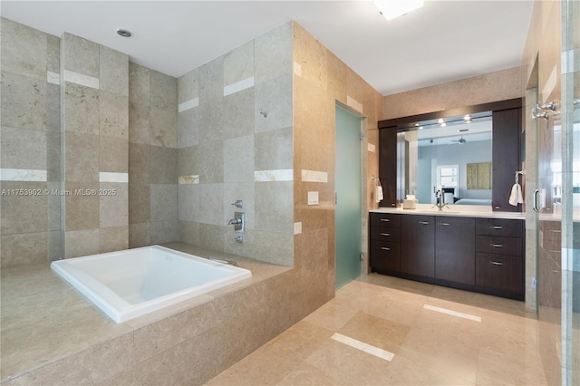 full bathroom featuring a garden tub, vanity, and tile walls