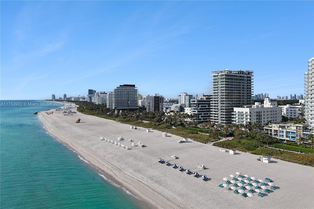 birds eye view of property with a water view, a view of city, and a beach view