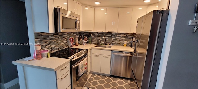 kitchen featuring stainless steel appliances, tasteful backsplash, modern cabinets, and a sink