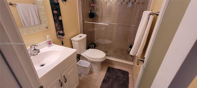 bathroom featuring toilet, a stall shower, tile patterned flooring, and vanity