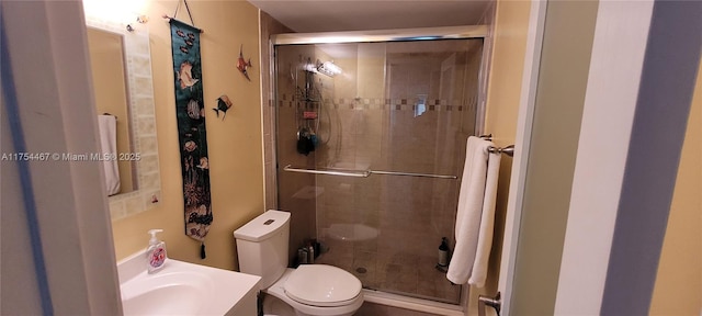 bathroom with toilet, a shower stall, and vanity