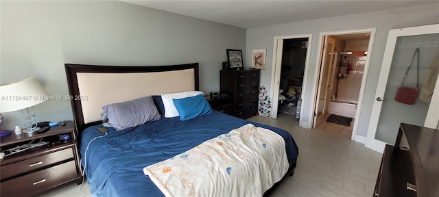 bedroom with wood finished floors and connected bathroom